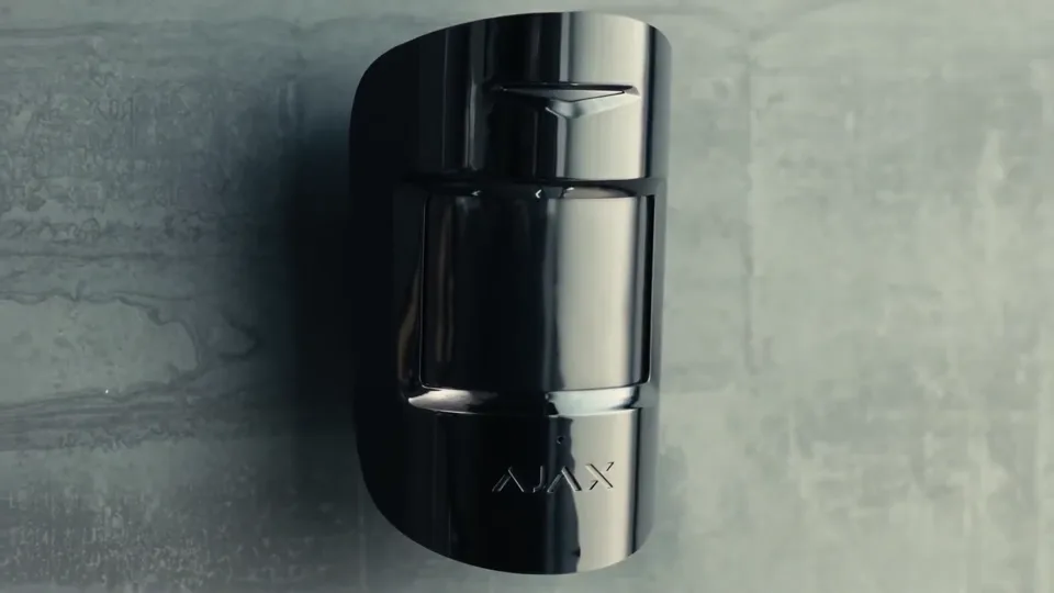 Detector de movimiento Ajax instalado en una pared de concreto