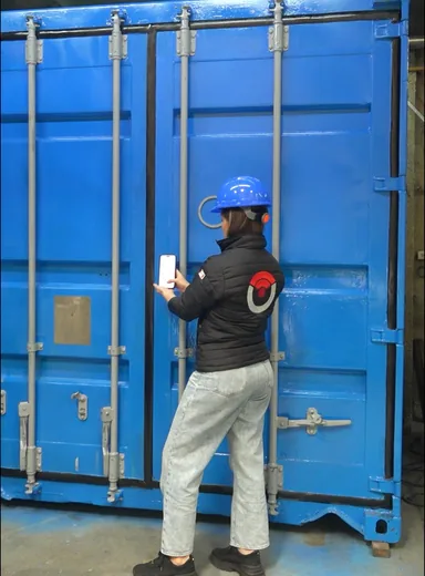 Técnico abriendo un contenedor con el celular