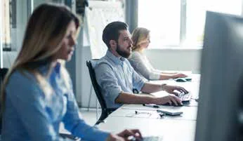 Personal de oficina atendiendo desde su puesto de trabajo