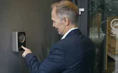 Persona usando un intercomunicador en la entrada de un edificio